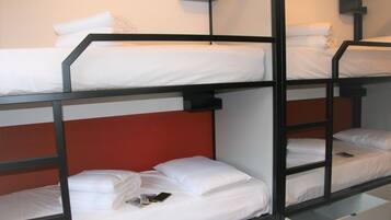 Habitación con literas, ropa de cama blanca y cabecero rojo.