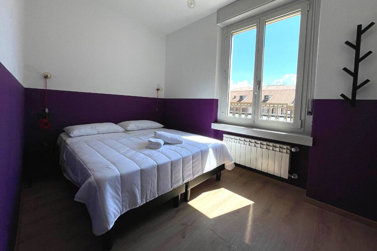 Une chambre à coucher avec un lit, une fenêtre et un radiateur.