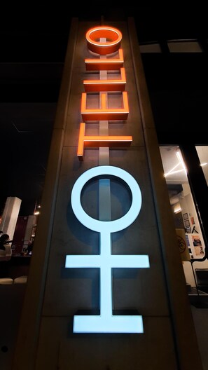 A hotel sign with illuminated letters and a symbol.