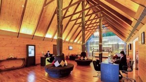 Un hall espacioso con pisos de madera, una recepción y zonas de estar.