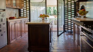 Una cocina con armarios de madera, una isla central y una estantería para vinos.