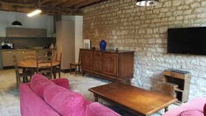 Ein gemütlicher Wohnbereich mit Steinwand, Holzmöbeln und einem Flachbildfernseher.