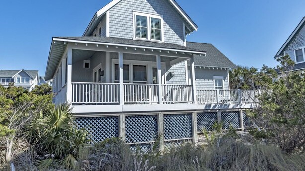 A two-story house with a balcony and a covered porch. - Sandcastle by the Sea - 3Bedroom, 2 Bath/Sleeps 6 - South Beach - Oceanside  (Bald Head Island)