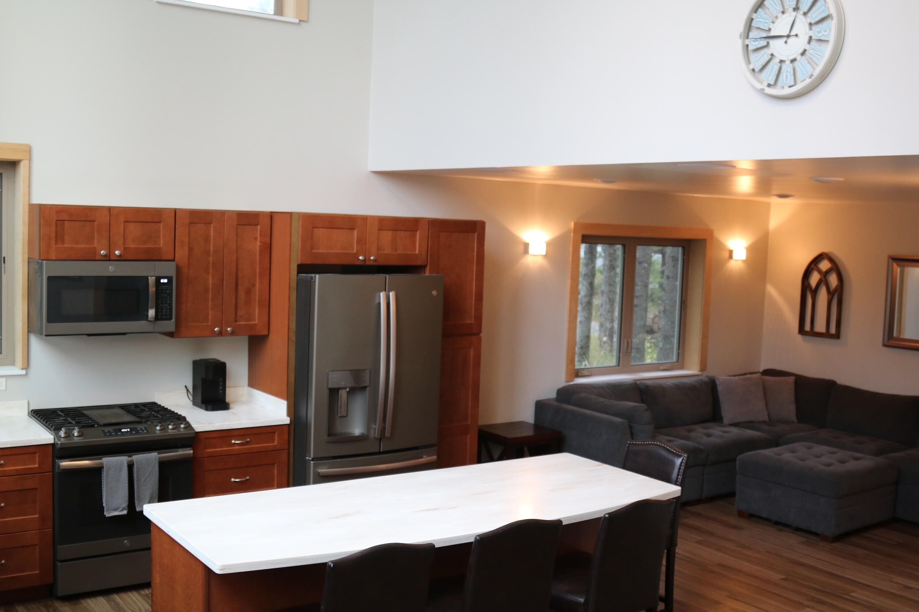 Una cocina moderna con microondas, estufa, refrigerador y un comedor con mesa y sillas.
