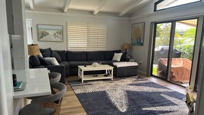 A modern living room with a dark grey sofa, a white coffee table, and a patterned rug. - Stand alone villa  (Venice)