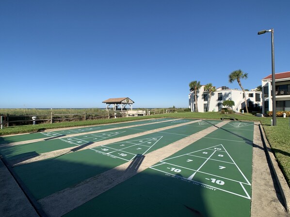A green shuffleboard court with a gazebo in the background. - Stand alone villa (Venice)