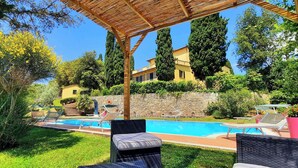 A pool area with lounge chairs and a pergola. - Villa Il Giardino with Private Swimming Pool, Garden, Ideal for Weddings (Radicofani (SI))