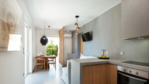 A modern kitchen with a built-in oven, a dining area with a table and chairs, and a large window with curtains. - Elisa Seaside Luxury Suite Private hot Tub, Beach (Loutraki-Agioi Theodoroi)