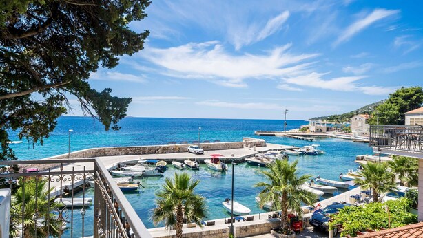 A marina with boats docked, a clear blue sky, and a view of the sea. - Apartments Villa Palma (Zupa dubrovacka)