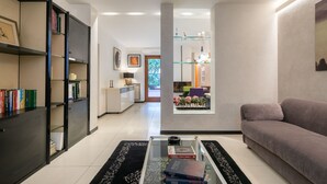 A modern living room with a sofa, a glass coffee table, and a bookshelf. - Ponte Rosso Modern by Mmega (Florence)