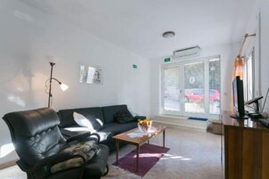 Apartamento (One-Bedroom Apartment with Balcony) | Sala de estar | TV de tela plana 25 polegadas com canais a cabo, TV