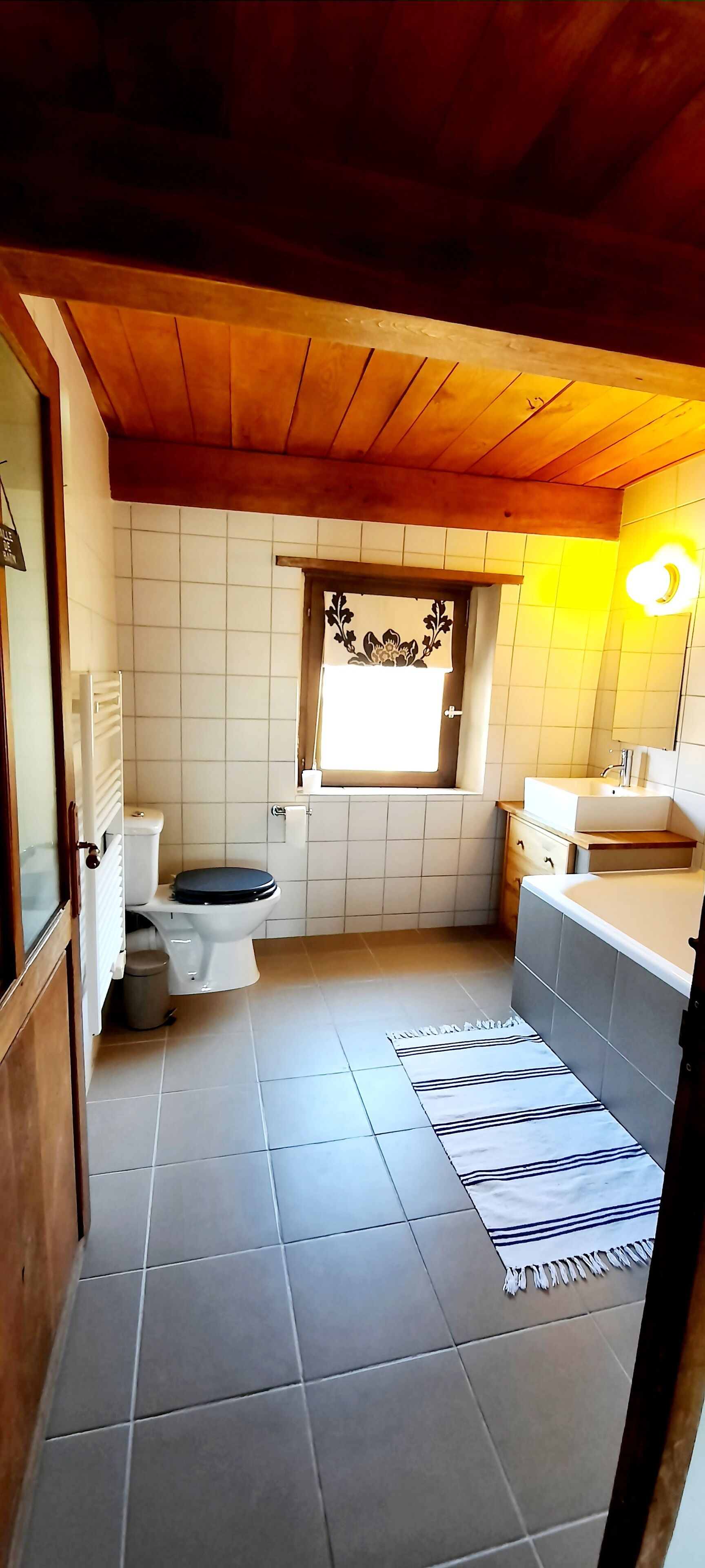 A compact bathroom with a toilet, sink, and window.
