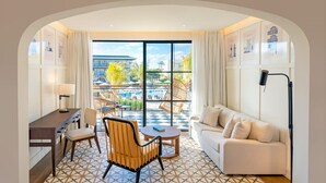 A hotel room with a balcony, a sofa, a dining table, and a desk. - Ocean El Faro - Privilege RoofTop Junior Suite Pool view (Punta Cana)
