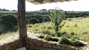 A stone wall with a wooden post and a metal roof structure.