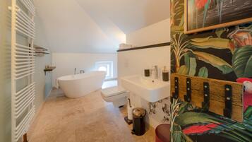 A bathroom with a freestanding bathtub, a sink, and a toilet.