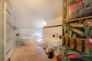 Une salle de bain avec une baignoire sur pieds, un lavabo et des toilettes.