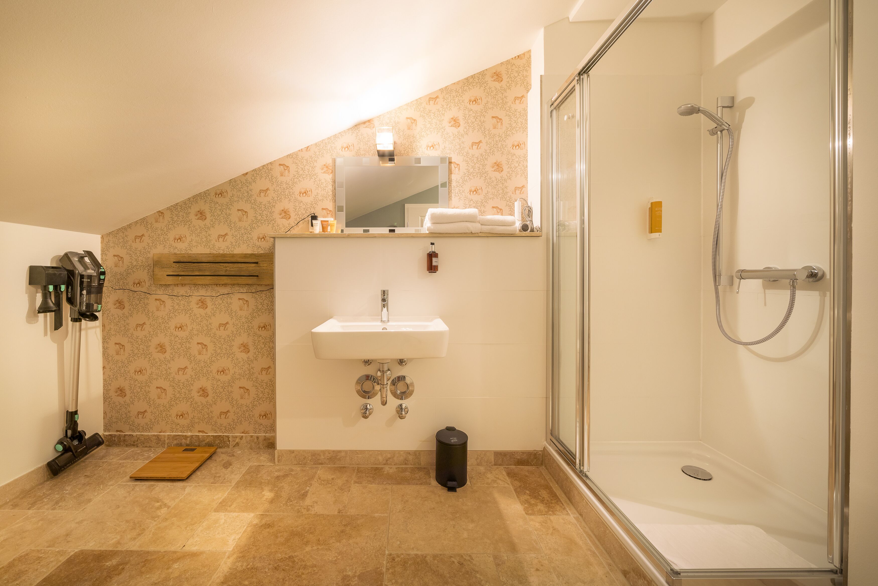 A bathroom with a shower, sink, and mirror.