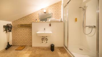 A bathroom with a shower, sink, and mirror.