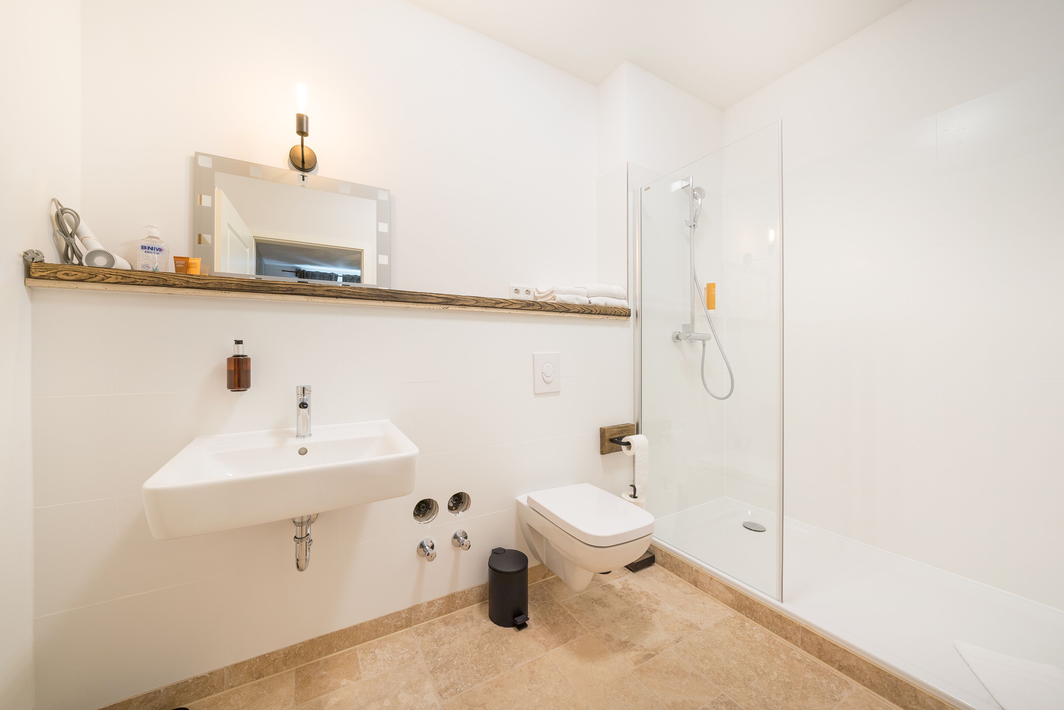 A modern bathroom with a sink, toilet, and glass shower.