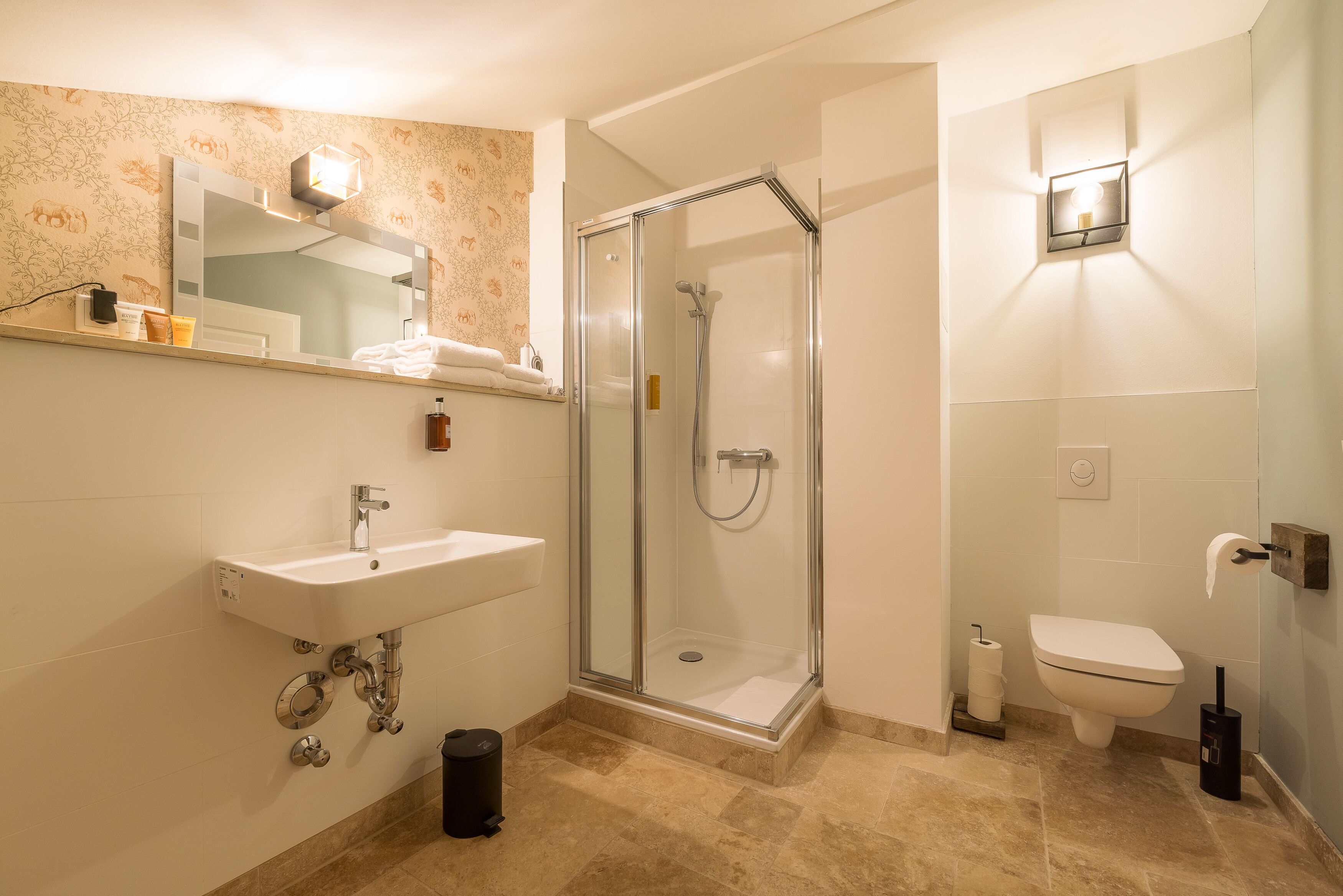 Un bagno moderno con cabina doccia in vetro, lavabo con specchio e water.