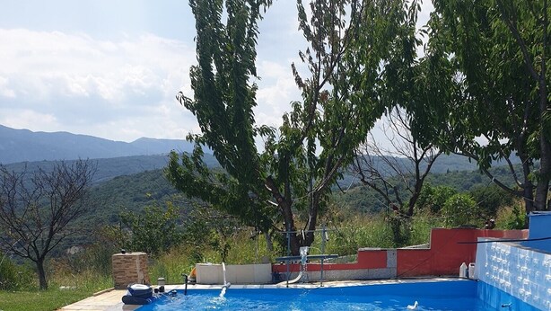 A swimming pool with a person floating on an inflatable raft. - Charming 4-bed House in Pyrgetos (Tempi)