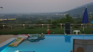 A swimming pool with lounge chairs and a view of the countryside. - Charming 4-bed House in Pyrgetos (Tempi)
