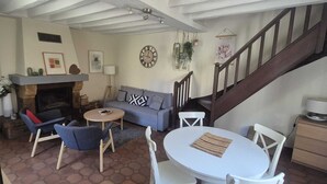 Ein Wohnzimmer mit Kamin, Sofa und Essbereich.
