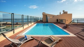 A pool area with lounge chairs and a view of the sea. - Luxury 2-Bedroom Apartment with RiaView & Rooftop Pool, Village Marina, Olhão (Olhão)