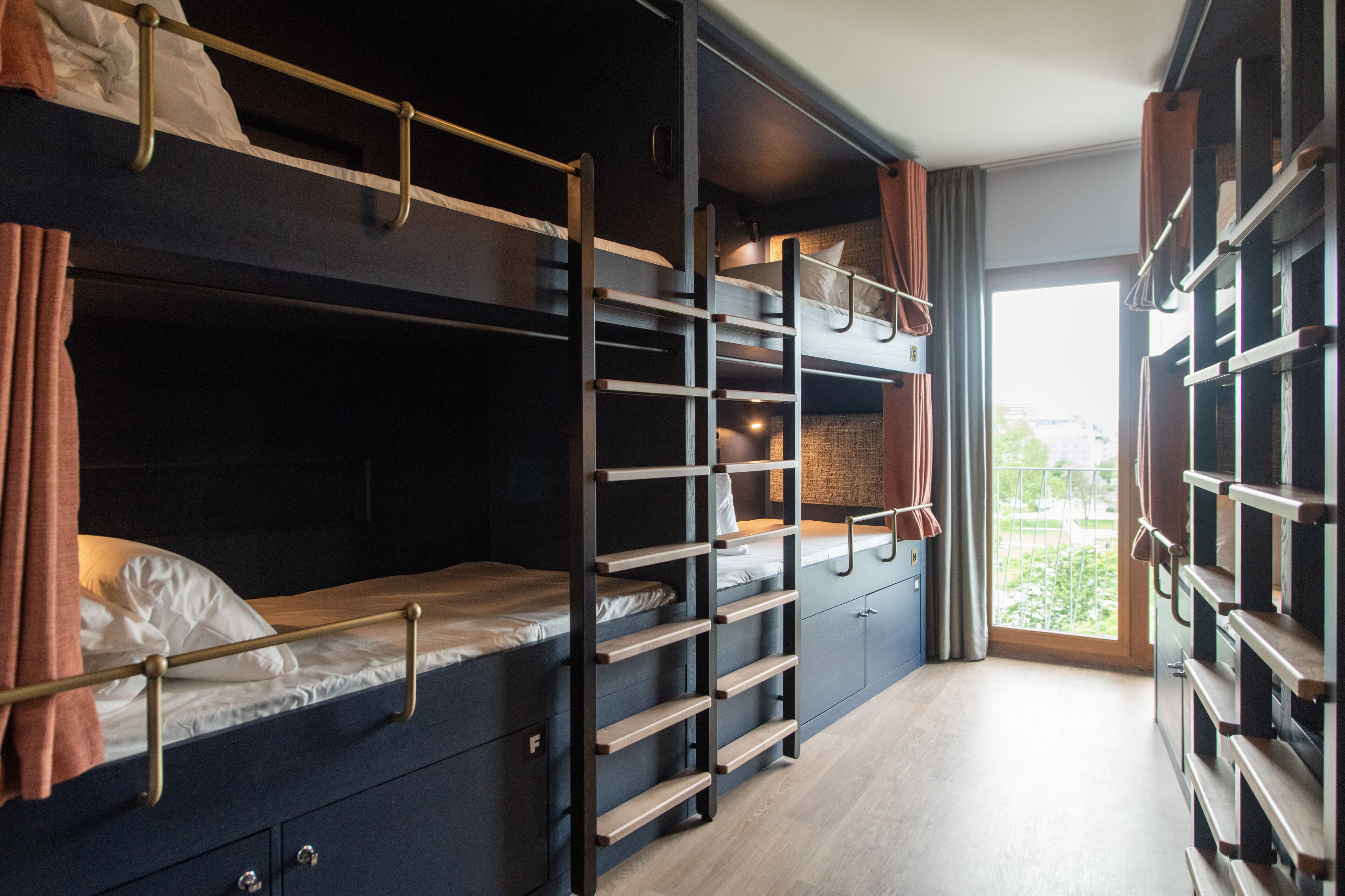 Habitación con literas, un armario y una ventana con cortinas.