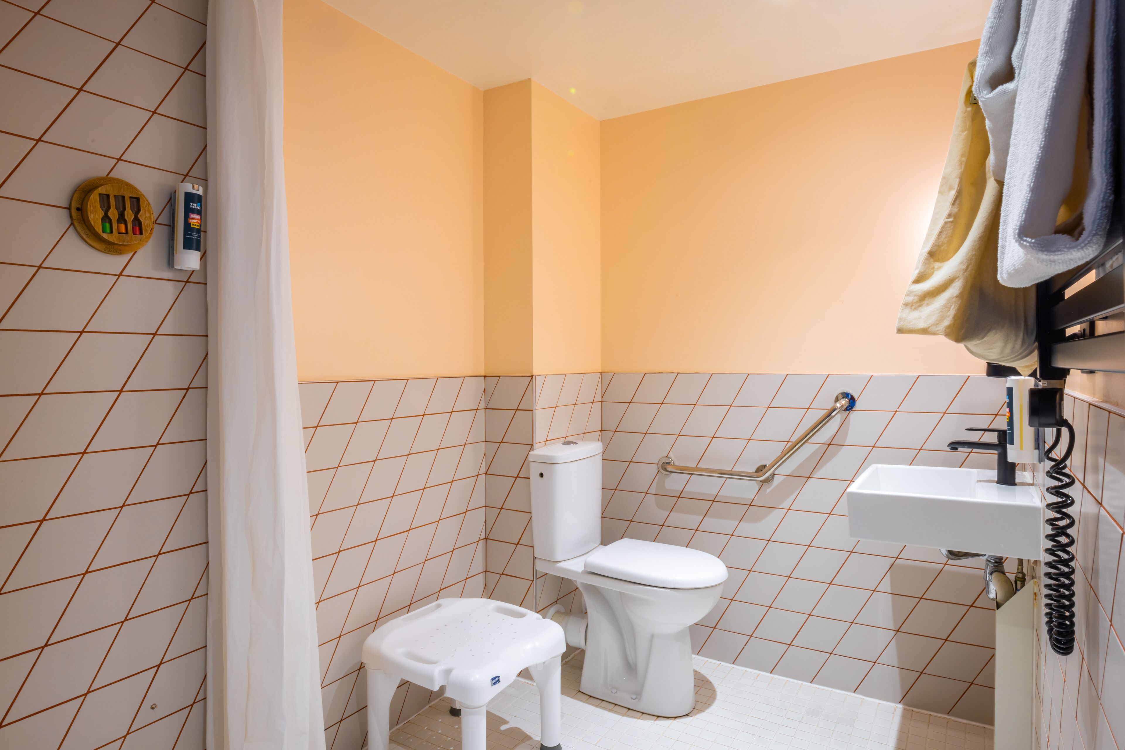 Une salle de bain comprenant des toilettes, un lavabo et un espace douche.