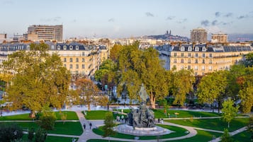 Un parque con una estatua central rodeada de césped y senderos.