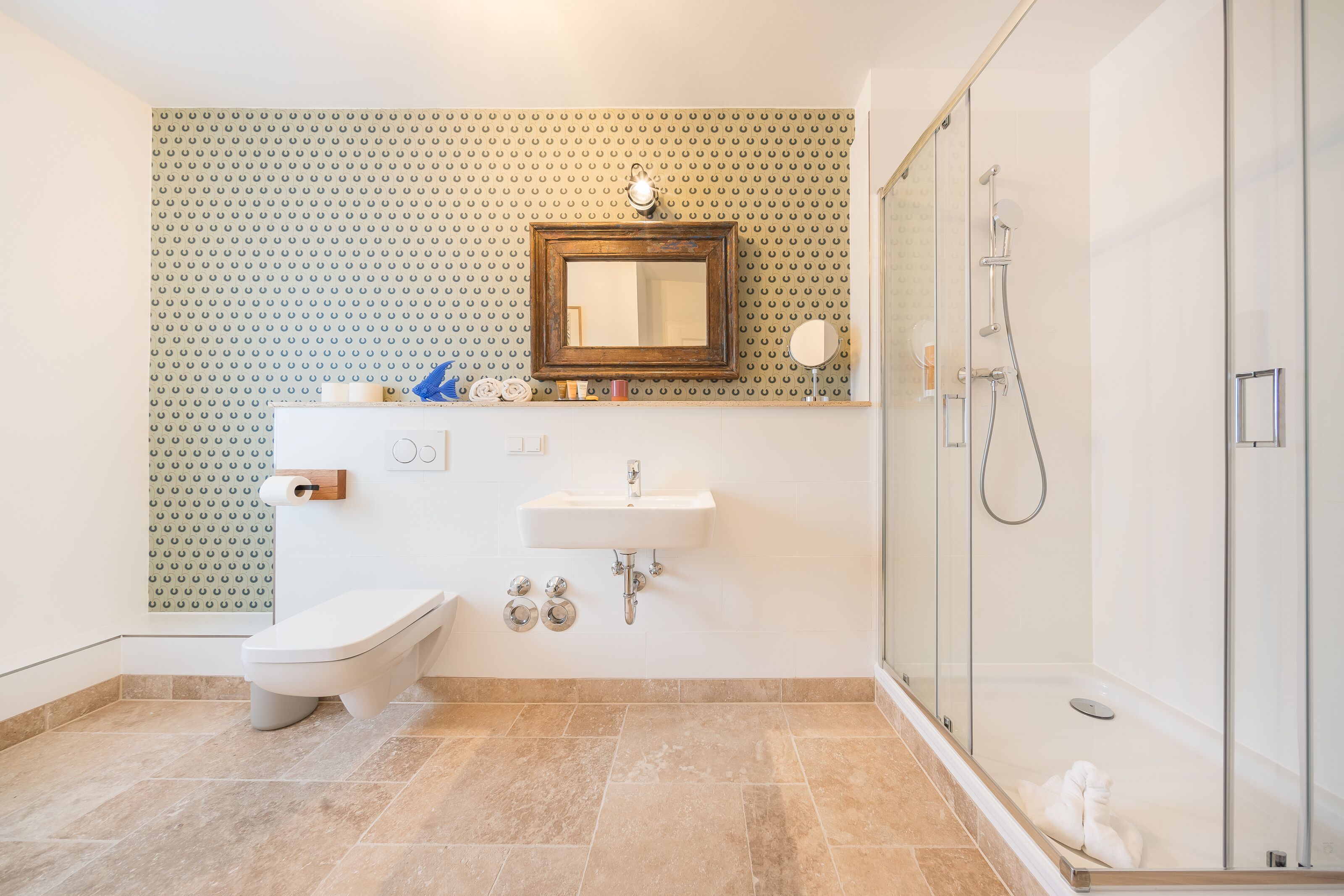 A modern bathroom with a toilet, sink, and shower.