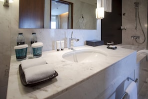 A modern bathroom with a large sink, two bottles of water, a towel, and a mirror. - Enjoy your stay at the Address Dubai mall - 1 bed (Dubai)