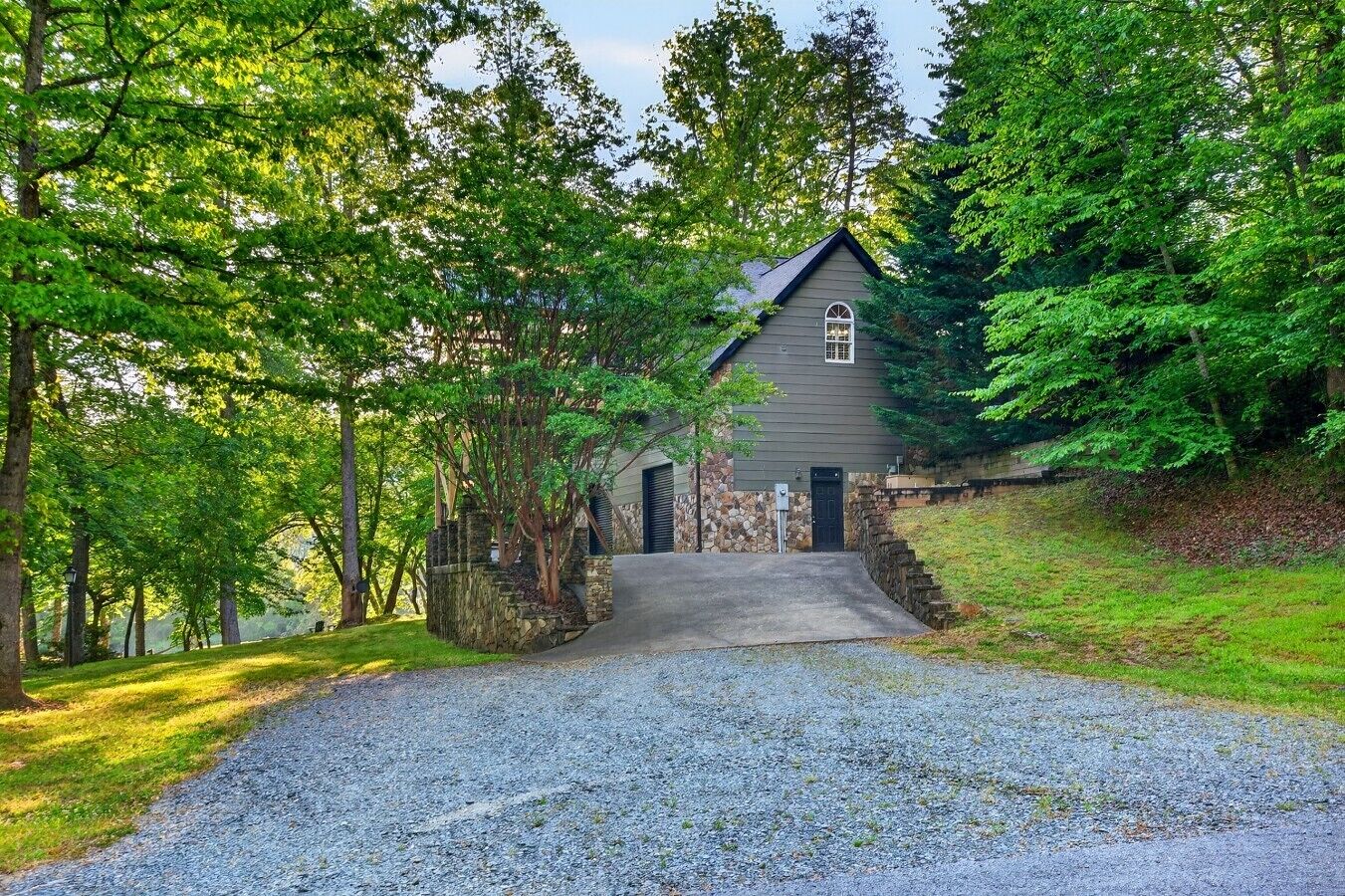 A house with a stone foundation, a grey exterior, and a front entrance.