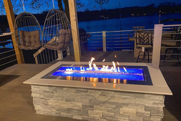 Relax by the outdoor fireplace overlooking the lake