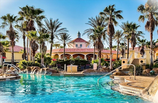 Un resort con piscina, palmeras y un edificio de techo rojo.