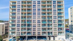 A multi-story hotel with balconies, a parking area, and a clear view of the surrounding area. - Stunning Top-Floor 3 Bedroom, 2 Bath Oceanfront Condo 902 Pinnacle (North Myrtle Beach)