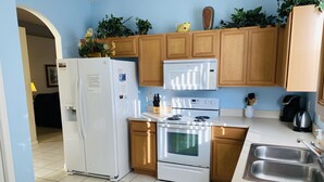 Une cuisine moderne avec des meubles en bois, un réfrigérateur blanc, une cuisinière et un évier.