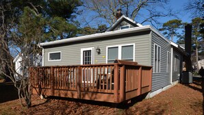 A two-story house with a wooden deck, a chimney, and a small window. - Pet Friendly Downtown Rehoboth Beach House (Rehoboth Beach)