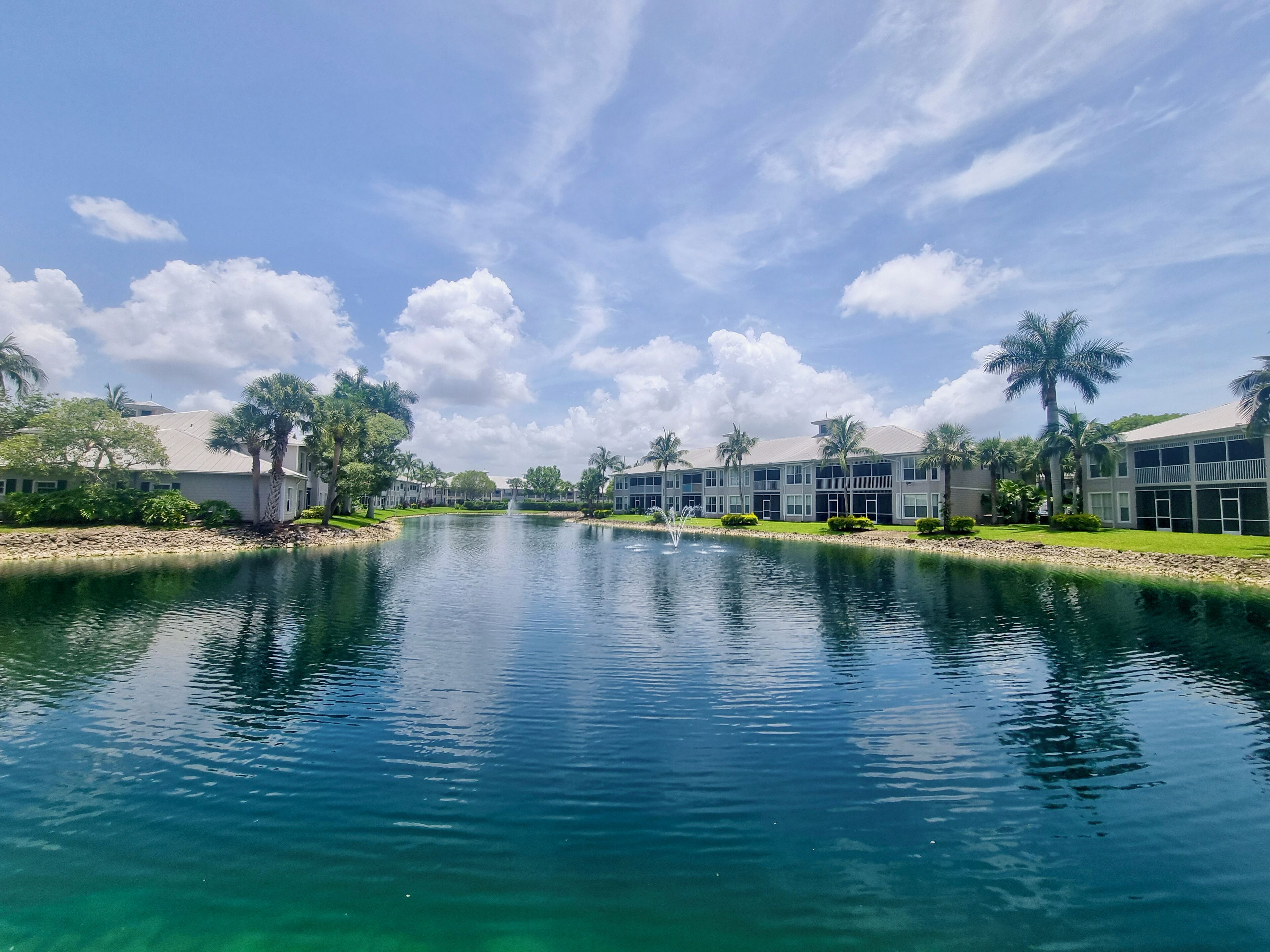 A serene waterway flanked by modern buildings with a clear sky above.