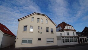 A two-story building with a flat roof and multiple windows. - Neue Ferienwohnung für 2 P. in Sehr Guter Lage! (Borkum)