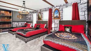 A bedroom with two beds, a stone wall, a bookshelf, and a chandelier. - Walk to Target, Private pool and SPA, StoreyLake 20037 (Kissimmee)