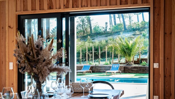 Comedor con vistas a una piscina y zona de estar al aire libre.
