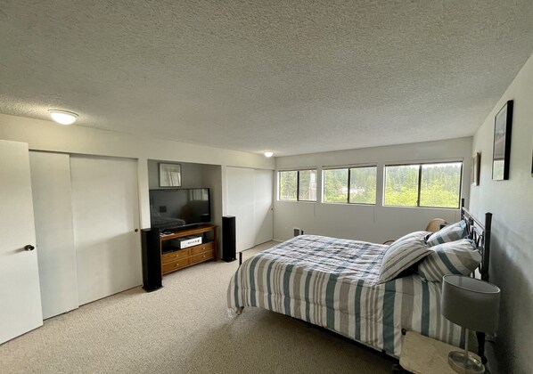 Relax in this serene bedroom with a large bed and stunning views of the surrounding greenery.