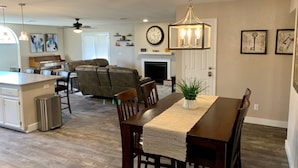 A spacious living area with a dining table, sofa, and kitchen in the background. - Havasu Retreat with Pool and  Game Room-pet friendly. (Lake Havasu City)