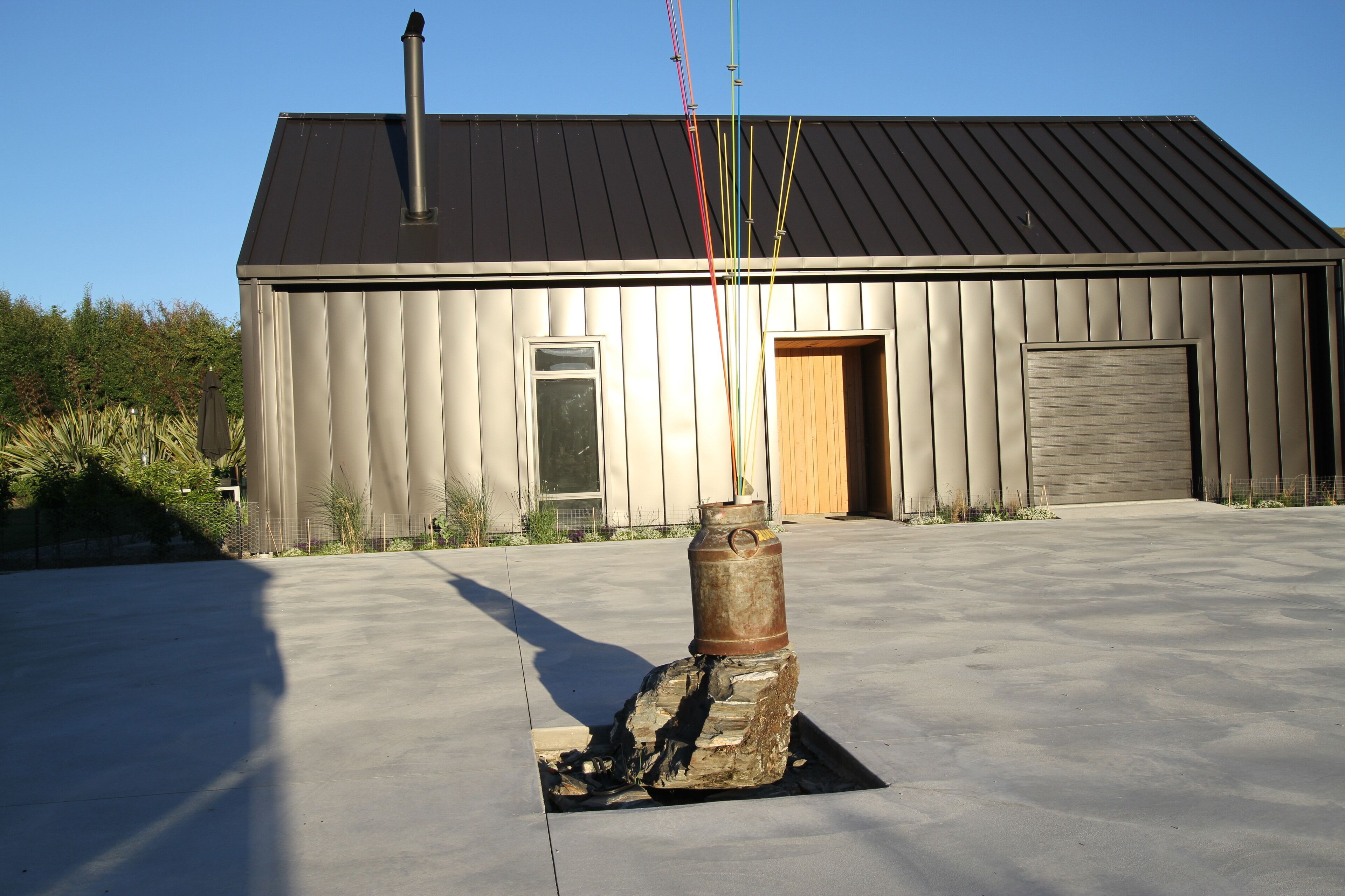 A building with a metal roof, a wooden door, and a large garage door.