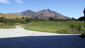 A residential driveway leading to a house with a mountain backdrop.