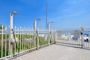 A white metal fence with a sign indicating security requirements for entry.
