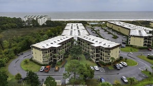 A modern apartment complex with a central courtyard, parking, and a view of the ocean. - Only 200 Steps to the Huge Oceanfront Pool (Hilton Head Island)