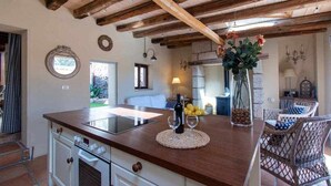 A kitchen with a central island, white cabinetry, and a wooden ceiling.